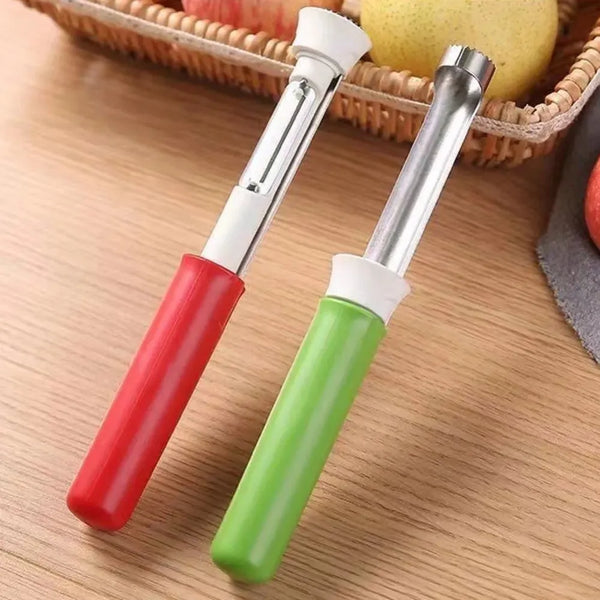Ein Paar roter und grüner Edelstahl-Obstkernentferner und -schäler auf einer Holzoberfläche neben einem Obstkorb