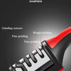 A close-up view of a red and black handheld knife sharpener showing various stages of grinding on a blade.