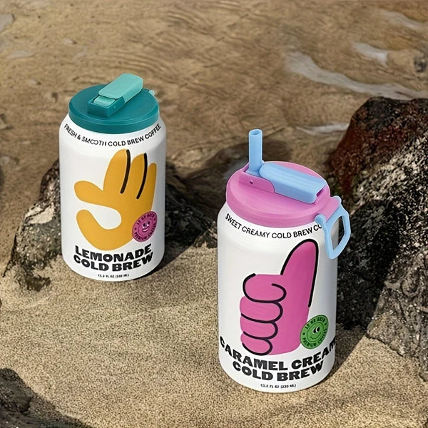 Two reusable drink cans labeled Lemonade Cold Brew and Caramel Cream Cold Brew resting on a rock.