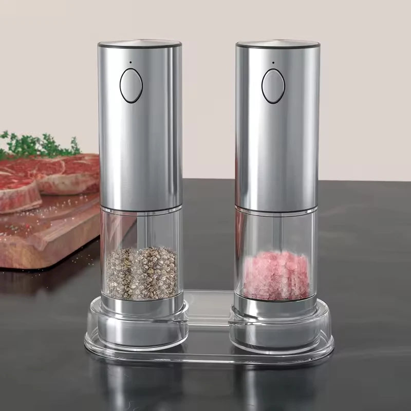 A silver automatic rechargeable salt and pepper grinder set with visible peppercorns and salt inside.
