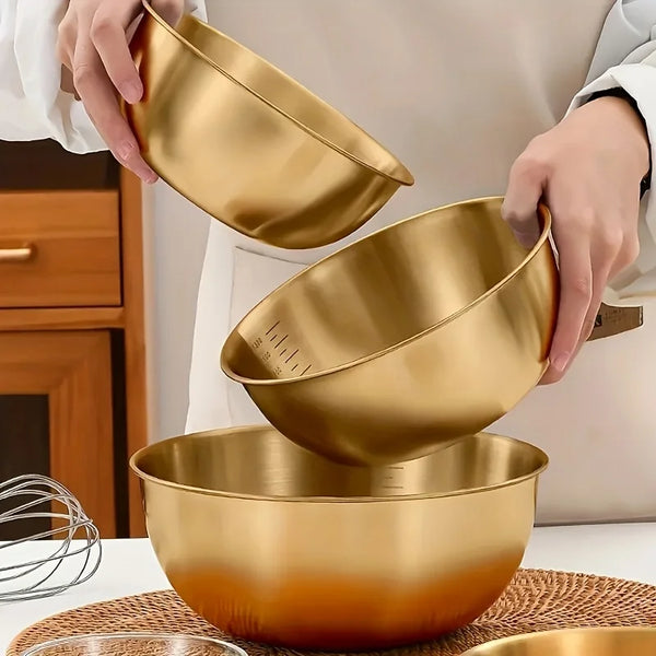 Drei goldfarbene Edelstahlsalatschalen mit Messmarkern, die von einer Person gehalten werden.