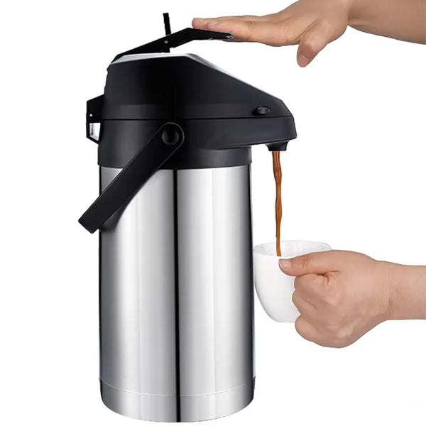 Eine Hand gießt Kaffee aus einem schwarzen isolierten Edelstahlspender in eine weiße Tasse.