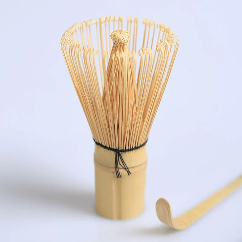 A bundle of thin bamboo tea straws tied together in a wooden holder with a single straw extending out.