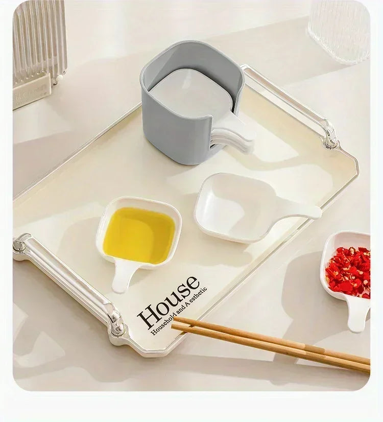 A set of seven plastic sauce dishes and a measuring cup arranged on a white tray with chopsticks.
