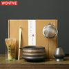 A box containing a Japanese matcha whisk set, including bamboo whisks and a metal whisk, displayed on a wooden surface.