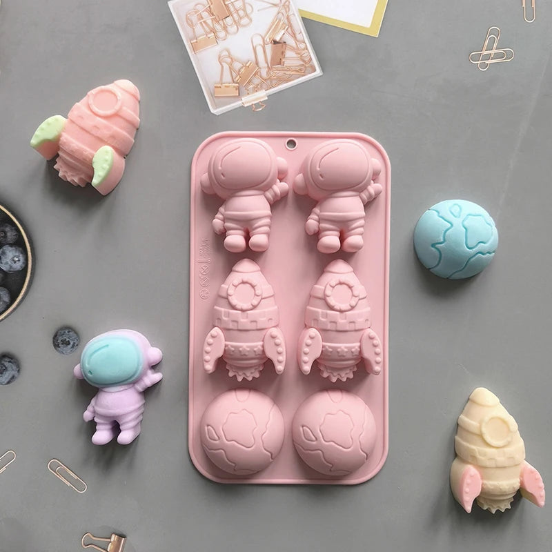 A pink silicone mold tray featuring various astronaut and planet shapes for DIY crafts.