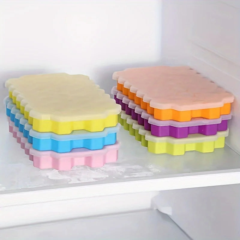 Una colección de moldes para cubitos de hielo reutilizables de silicona coloridos con tapas apilados en un estante blanco.