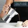A hand pours dark espresso from a silver moka pot into a white cup.