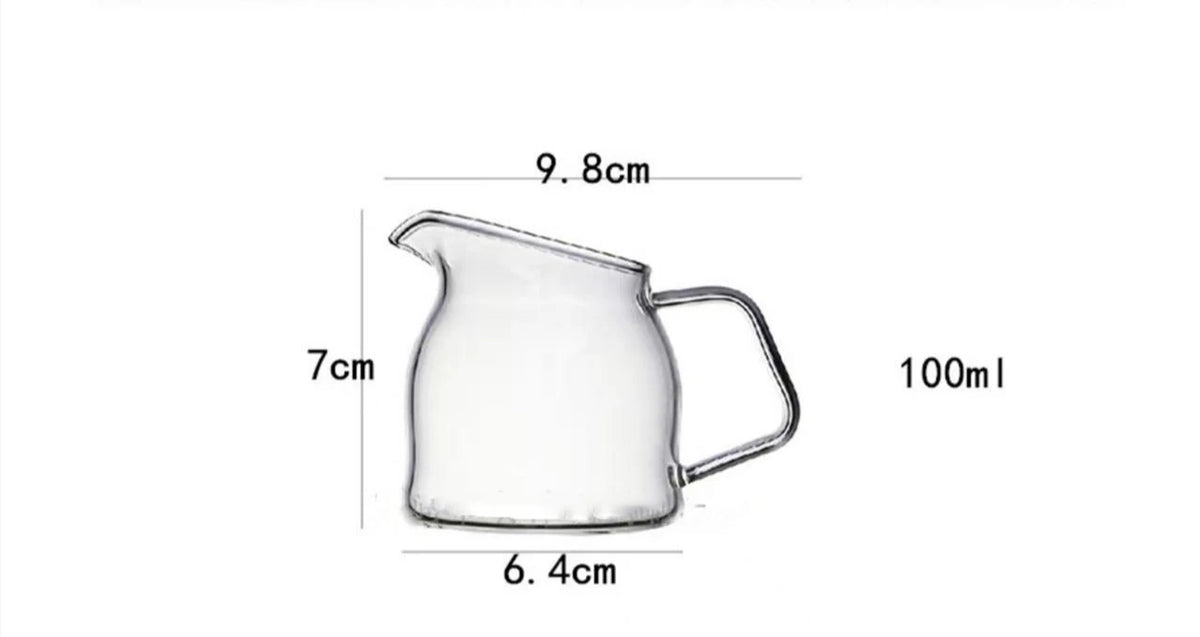 A clear glass pitcher with a handle, measuring 9.8cm in height and 6.4cm in width, designed for serving liquids.