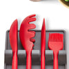 A silicone utensil drying rack organizer holding various red silicone kitchen tools like a knife and brush.