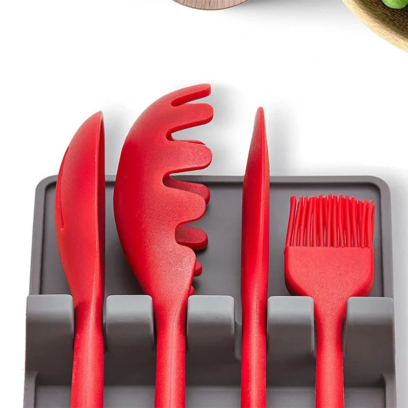 A silicone utensil drying rack organizer holding various red silicone kitchen tools like a knife and brush.