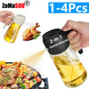 A hand is holding a black 2-in-1 oil sprayer and pourer bottle filled with golden oil, next to a cooked chicken and food on a