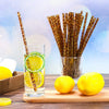 A glass of lemon-infused water with citrus slices and a reusable plastic straw set in the background.