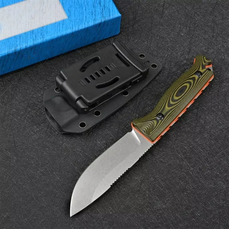 A fixed blade outdoor camping knife with a black handle and a silver blade resting on a dark surface next to a blue box.