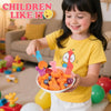 A smiling girl holds a bowl filled with orange and purple pressed fruit and vegetable cutting molds.