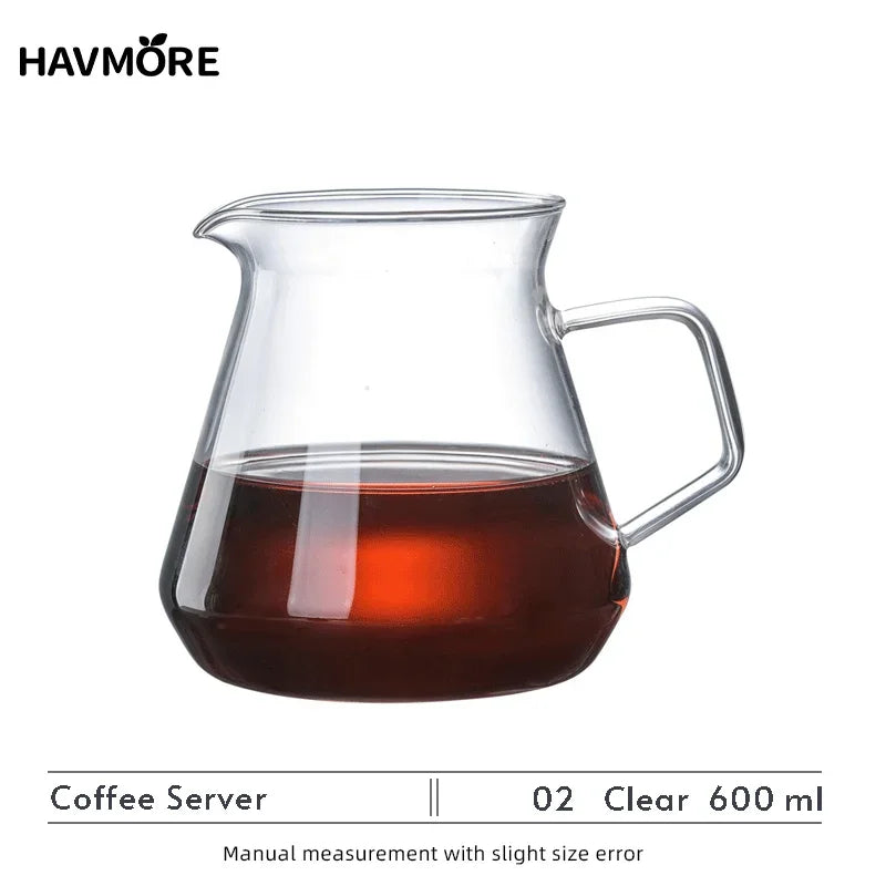 A clear glass coffee server with a handle containing dark brewed coffee.