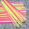 A bundle of colorful, translucent plastic beverage stirrers and straws in shades of pink, orange, and yellow.