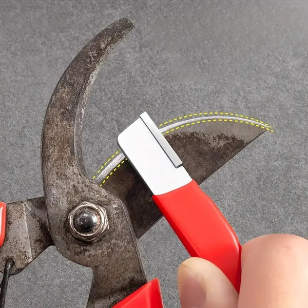 Eine Hand hält einen professionellen Multifunktionsmesserschärfer mit rotem Griff und silberner Klinge vor grauem Hintergrund
