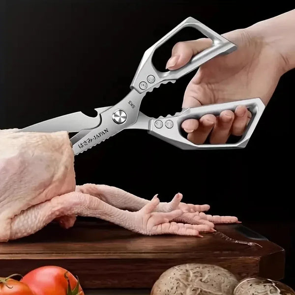 Eine Hand schneidet einen rohen Hähnchenfuß mit scharfen Küchenscheren auf einem Holzbrett.