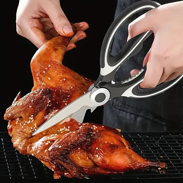 Hände verwenden schwere Edelstahl-Küchenschere, um ein gegrilltes Hähnchen auf einem Rost zu schneiden.