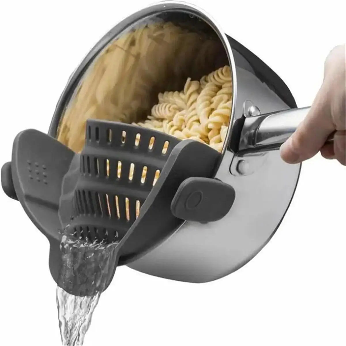 Una mano vierte agua a través de un colador de olla ajustable de acero inoxidable, dentro de una olla con pasta.