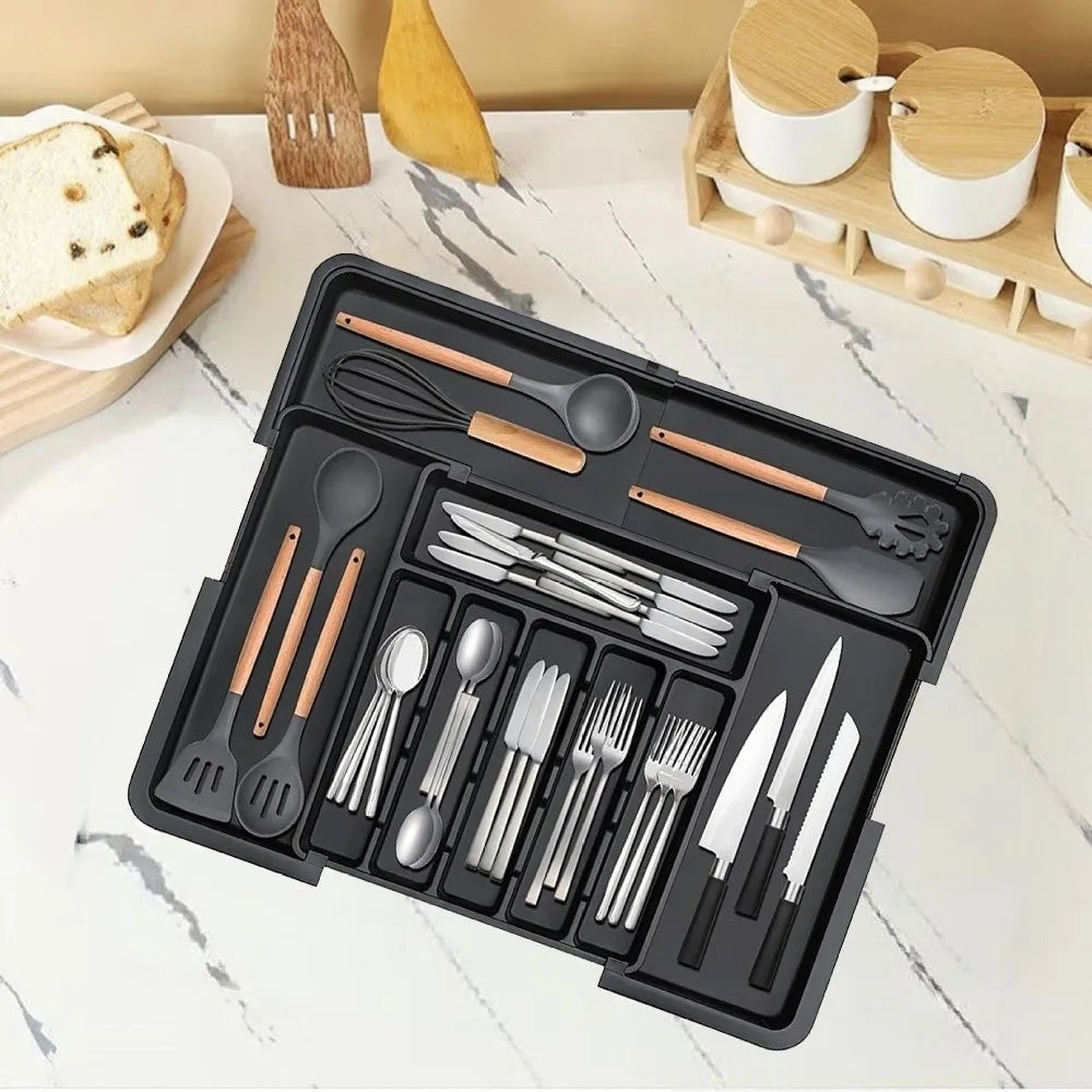 A black retractable cutlery drawer organizer tray filled with various stainless steel and wood-toned utensils.