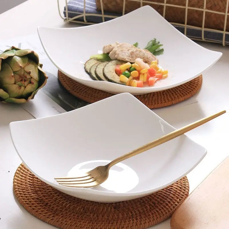 A white reusable PP salad bowl is shown on a woven mat with a gold fork resting on the rim.