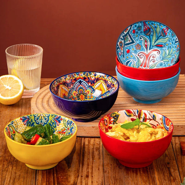 Eine Sammlung farbenfroher retro Keramikschalen mit gemusterten und einfarbigen Designs, präsentiert auf einer Holzoberfläche