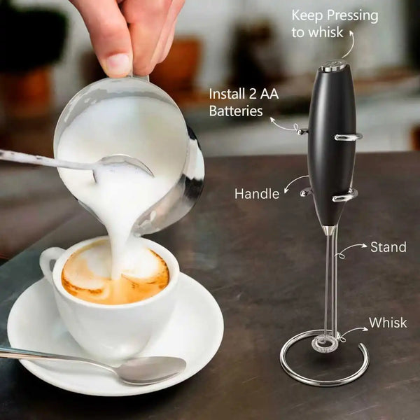 Eine Hand benutzt einen Handmilchaufschäumer, um Milch in einer Tasse für Kaffee aufzuschäumen.
