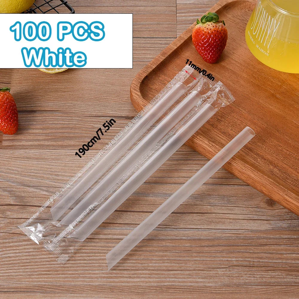 A pack of 100 white reusable plastic drinking straws is displayed on a wooden board next to strawberries.