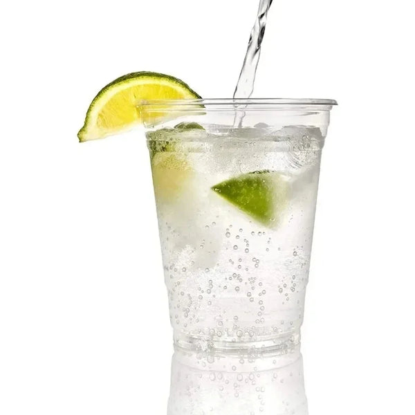 A tall glass filled with ice water and lime juice, garnished with a wedge of lime.