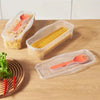 A set of clear plastic containers holds cooked noodles and salad ingredients on a wooden table.