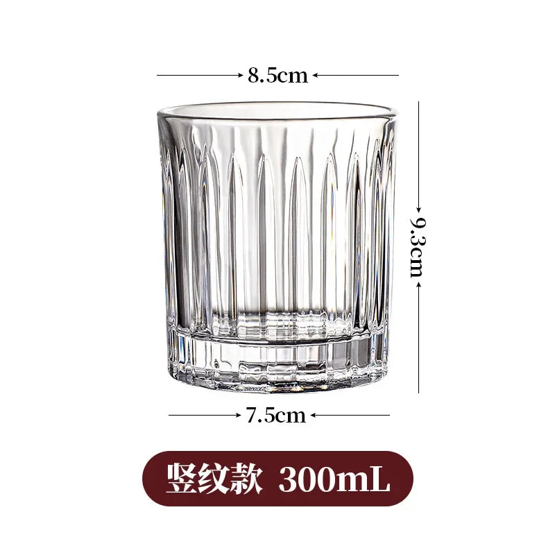 Vaso de whisky de vidrio transparente con textura estriada, mide 8.5 cm de alto y 7.5 cm de diámetro.