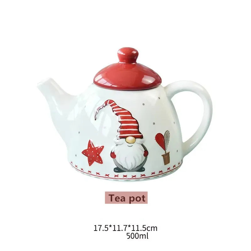 A white ceramic teapot with a red lid and a painted Santa face on the body.