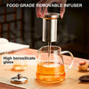 A hand pours liquid into an elegant borosilicate glass teapot using a stainless steel food grade removable infuser.