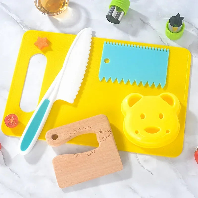 A yellow cutting board holds a white knife, a blue plastic grid, and a wooden cutting tool for toddlers.