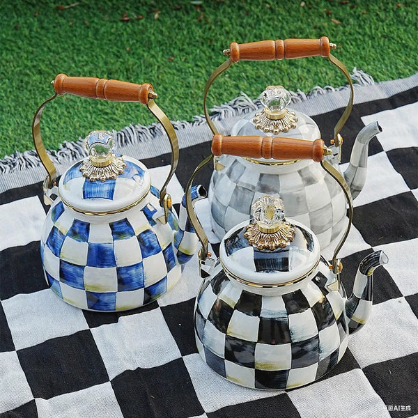 Vintage Emaille-Wasserkocher mit blau-weiß kariertem Muster auf schwarz-weiß kariertem Stoff.