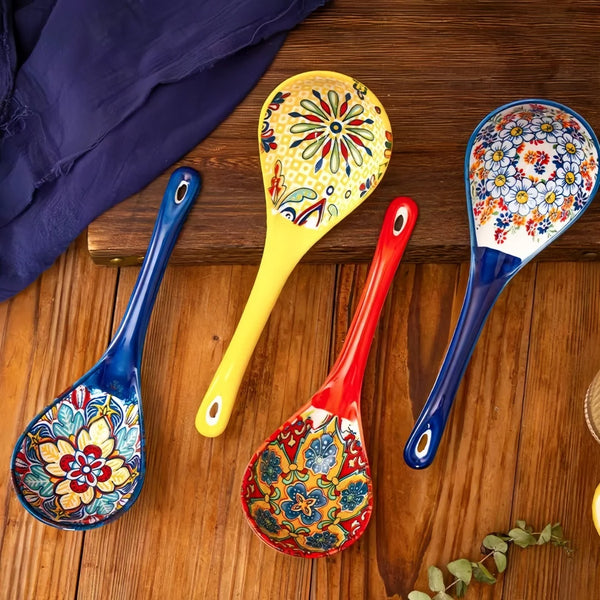 Ein Set aus zwei farbenfrohen Boho-Keramik-Servielöffeln in Gelb-, Rot- und Blautönen, auf einer Holzoberfläche.
