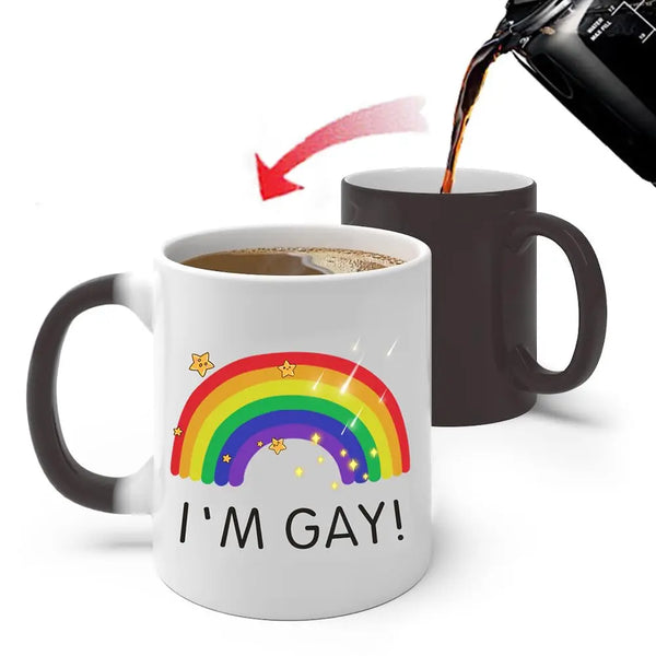 A white ceramic mug with rainbow stars and the text I'M GAY is shown next to a dark mug being filled with liquid.