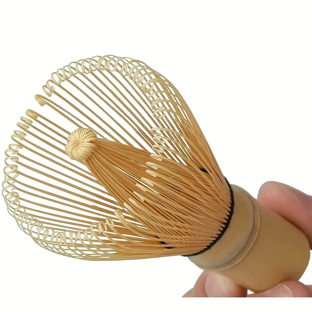 A natural bamboo tea tools set featuring a wide, fine-bristled comb attached to a wooden handle.