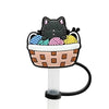 A silicone straw cover shaped like a black cat sitting in a bowl filled with colorful straws.