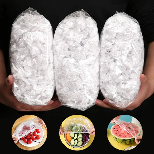 Drei Beutel wiederverwendbare Plastik-Lebensmittelfolien neben frischem Obst und Gemüse.