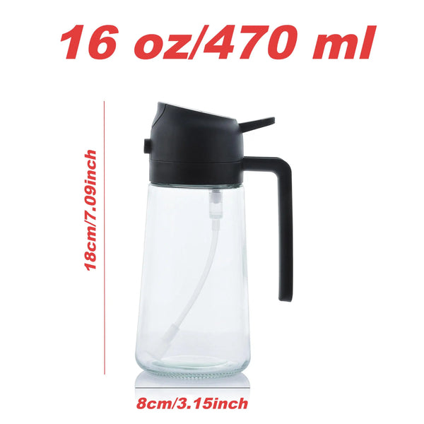 A clear glass olive oil sprayer bottle with a black cap and handle, shown next to a measurement scale.