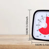 A black visual countdown timer for kids with a red dial and markings, displayed on a wooden surface.