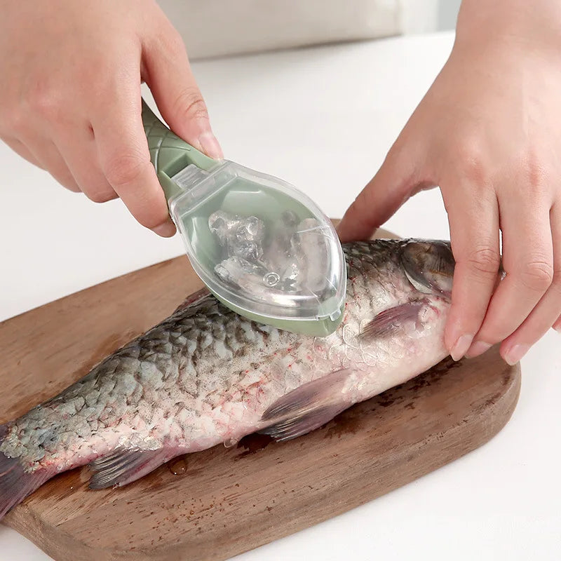 Hands are using a green plastic scraper to clean a fish lying on a wooden cutting board.