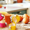 A set of colorful portable tools for opening and separating egg shells on a wooden surface.