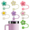 A set of pink and green flower straw caps for tumblers, showing various colors and designs.