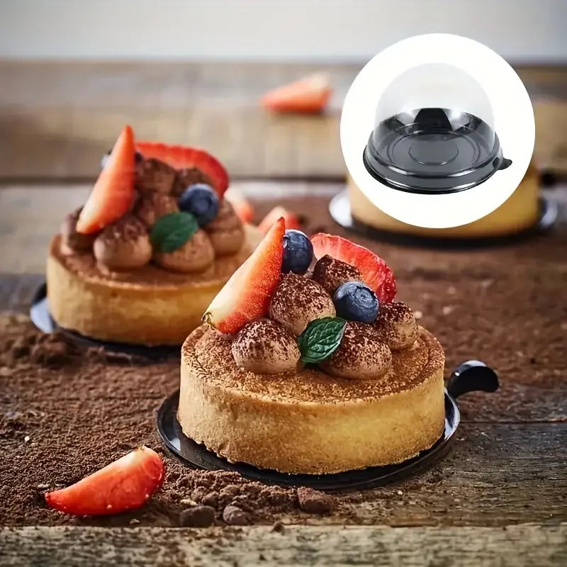 A small tart topped with strawberries and blueberries is displayed on a dark plate, with a transparent lid shown in an inset 