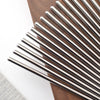 A set of sleek stainless steel chopsticks laid diagonally on a dark wooden surface.