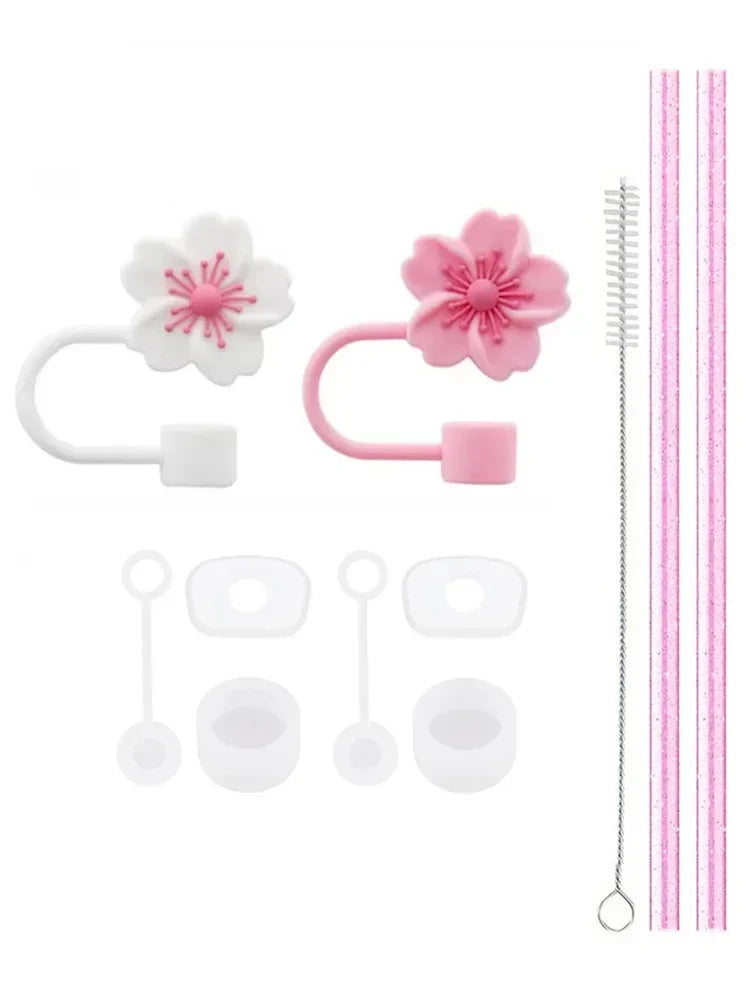 A set of reusable silicone straw covers and cleaning brushes with pink and white floral designs.